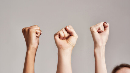 Close up of three raised fists of diverse women. Feminism, equality and women liberation concept