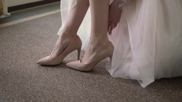 Bride put on wearing wedding shoes. Bridal footwear, morning dressing