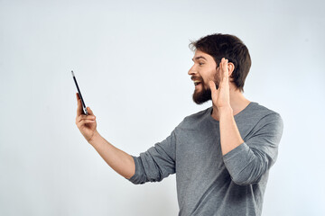 A man with a tablet in his hand internet technology communication gray jacket light background