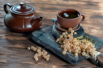 White currant tea Cup with berries on wooden background with teapot and Cup