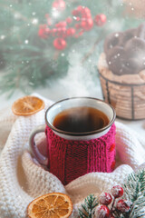 Hot winter tea in a red mug with orange chips and a warm scarf - rural still life. Copy space