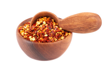 Chili and paprika in wooden bowl and spoon, isolated on white background. Mix of hot and sweet red pepper with grains.
