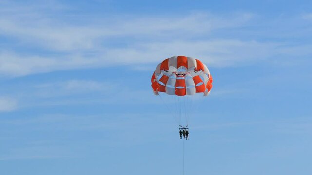 People are resting flying on parasailing in the sky, outdoor activities.