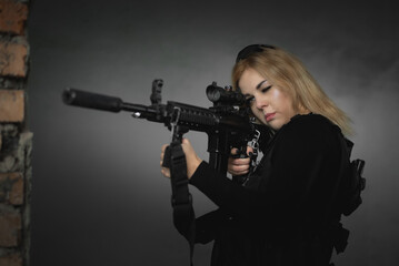 A girl soldier with a rifle in abandoned building.