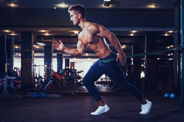 Fototapeta premium Young athlete doing exercises with a resistance band.