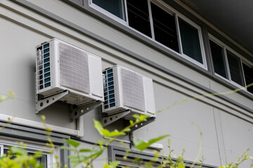 Air conditioner compressor installed in old building. Outdoor split wall type air conditioner compressor unit inverter installed on the outside of the building. Air conditioner compressor outdoor unit