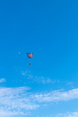 Parachutist is flying in the sky, sunny contrast image.