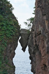 Niigata,Japan-October 19, 2020: A wedge-shaped rock between two giant rocks or Benkei no Hasamiiwa at Sado island, Japan

