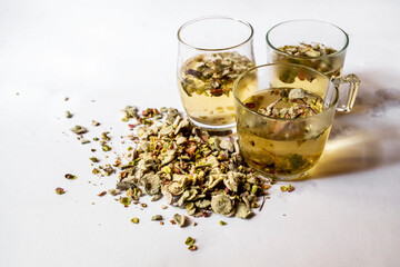 3 glass cup of tea and pile of dried leaf and flower of Origanum Dictamnus.
