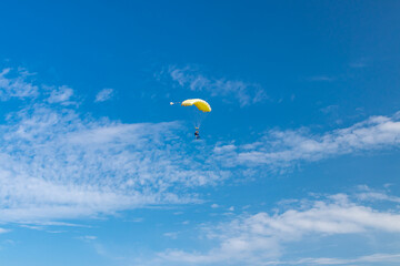 Parachutist is flying in the sky, sunny contrast image.