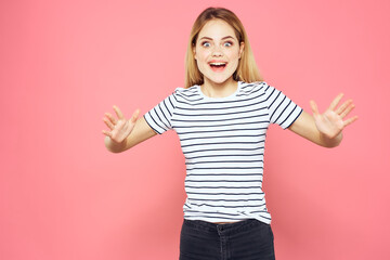 Cheerful woman striped t-shirt lifestyle emotions and gestures with hands pink background