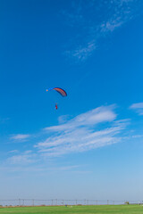 Parachutist is flying in the sky, sunny contrast image.