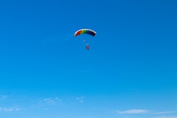 Fototapeta na wymiar Parachutist is flying in the sky, sunny contrast image.