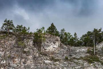 Scenery landscape with green forest and high rocky mountain under dark blue sky. dramatic nature