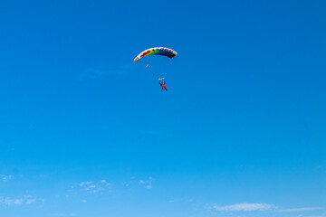 Fototapeta na wymiar Parachutist is flying in the sky, sunny contrast image.