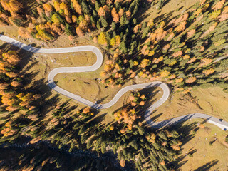 TOP DOWN: Lone white car cruises along the switchback road in the Dolomites.