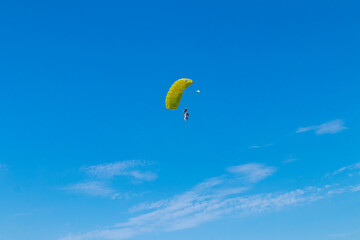 Parachutist is flying in the sky, sunny contrast image.