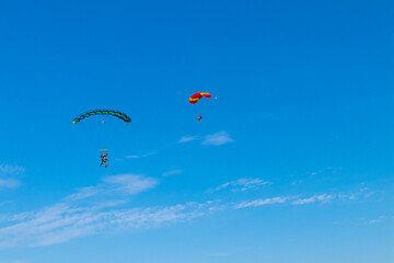 Parachutist is flying in the sky, sunny contrast image.