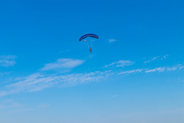 Parachutist is flying in the sky, sunny contrast image.