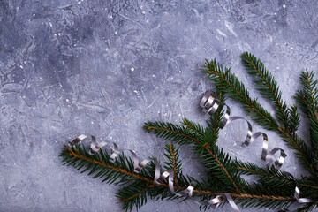 Beautiful blue snowy Christmas background with fir branches, ribbon.