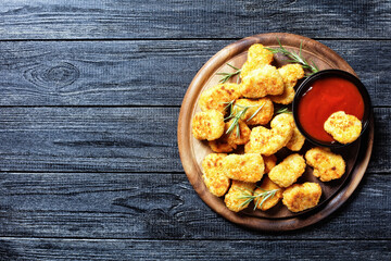 Crispy chicken nuggets on a round cutting board