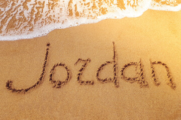 Jordan title on the sand beach of the coast Red sea. Wave.
