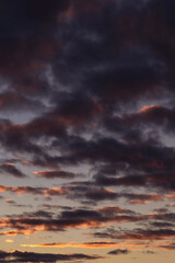 Fototapeta na wymiar Epic dramatic sunset, sunrise sky with dark violet clouds in orange yellow sunlight 