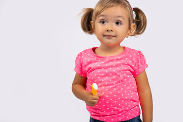  Portrait of a small, cute and beautiful girl with ponytails and lollipop in her hands. Photo on white background with empty side space