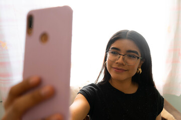 woman with glasses using her phone to take a picture