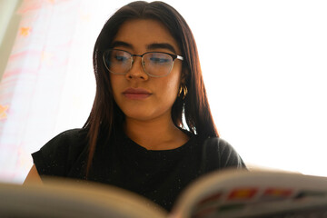woman with glasses and long hair reading a book