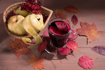 Autumn drink mulled wine on a dark wooden background with autumn leaves, viburnum berries and...
