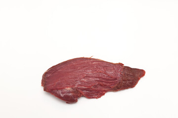 Large piece of meat on a light background. Beef tenderloin. Close-up, selective focus, copy space