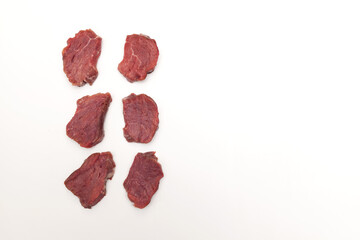 Juicy pieces of meat, top view. Beef sirloin (steaks) lie in rows. Close-up, copy space