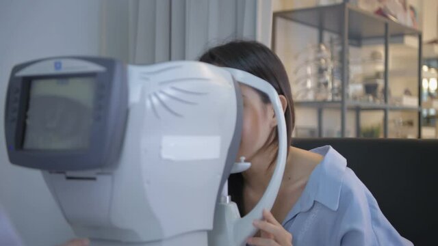Optical shop concept. The ophthalmologist is measuring the customer's eyes. 4k Resolution.