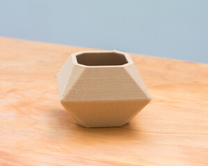 Shot of a 3d printed little bowl planter on a wooden surface