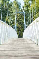 Fototapeta premium Low angle of a white bridge in a park on a sunny spring day