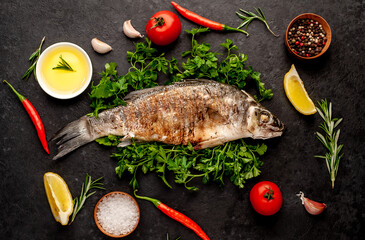 grilled sea bass with spices, herbs, and lemon on a stone background