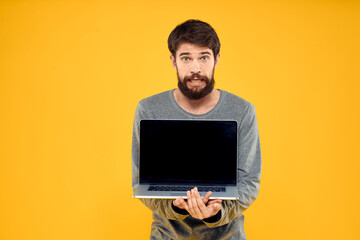 man with laptop wireless technology internet lifestyle work yellow isolated background