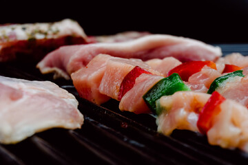 Selective focus. Raw skewer of chicken with pieces of red and green peppers, pork rib in a barbecue. Food. Life Style.