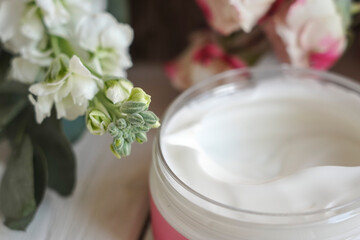 face cream, white, against flowers