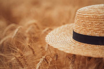 A straw hat lies on a wheat field.