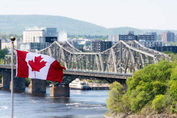 Canadian flag and a bridge over the Saint Laurent river