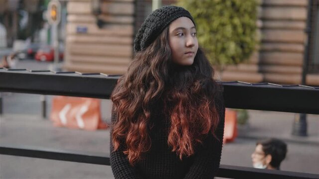 Vista de una adolescente por las calles de la Ciudad de M&eacute;xico con ropa de abrigo en una tarde de oto&ntilde;o, imagen urbana con una ni&ntilde;a con el sol en frente