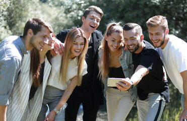 group of friends takes a selfie on the background of the city Park