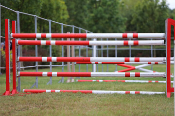 Obraz na płótnie Canvas Obstacles poles barriers for jumping horses as a background