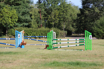 Fototapeta na wymiar Obstacles poles barriers for jumping horses as a background