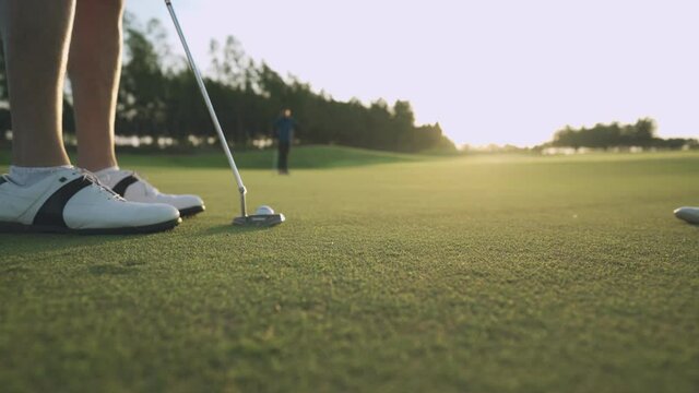 Sunset shot of golfer putting golf on green scoring birdie, focus concentration in the game, having fun in golf course , sports relax summer vacation, sport tournament competition, sport science