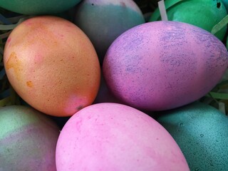 Easter Eggs Dyed. Painted easter eggs in a basket. Many colorful dyed easter eggs. Purple, Orange, pink, dyed eggs in celebration for easter. Springtime religions holiday eggs. 