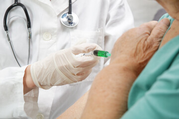 Senior woman receiving vaccine. Medical worker vaccinating an elderly patient against flu, influenza, pneumonia or coronavirus.