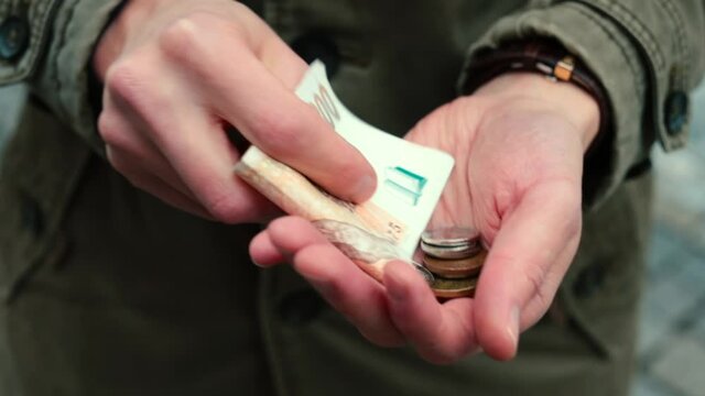 Czech money in the hands of a man. Close-up. The recession is forcing a return to a culture of thrift. European financial crisis.